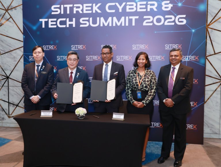 Five professionals stand behind a table as two in the center display signed certificates at SITREK Cyber & Tech Summit 2026, backdrop branding visible.